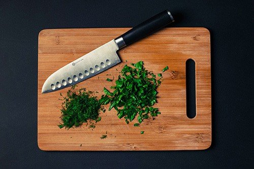 Cutting board with knife and chopped parsley