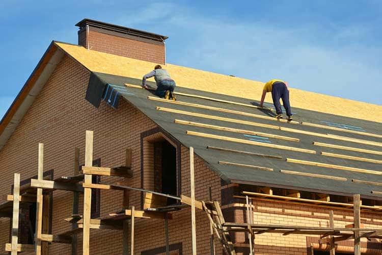 Roofing contractors are installing underlayment, waterproofing m