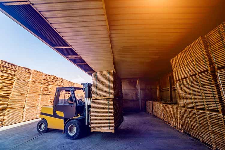 Forklift loader load lumber into a dry kiln. Wood drying in containers.