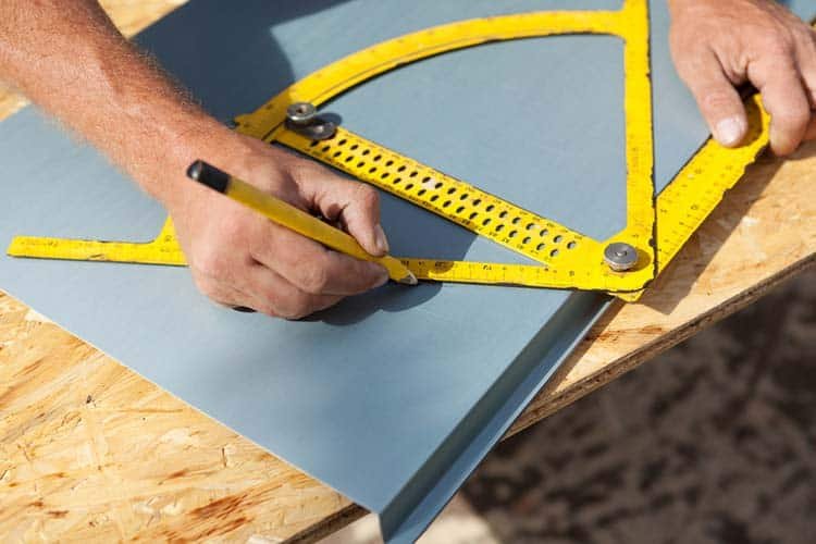 Roofer working with a protractor on a metal sheet