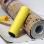 Roll of wallpaper and roller ready to work
